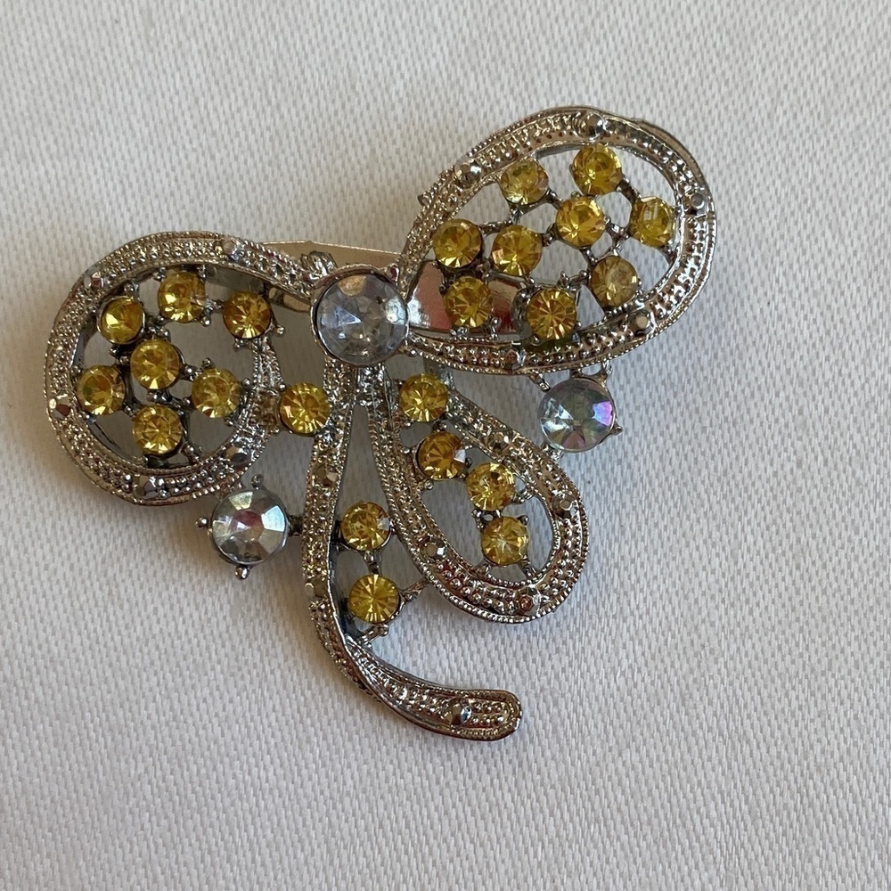 Vintage Brooch Pin set in silver tone metal with yellow and clear crystals.